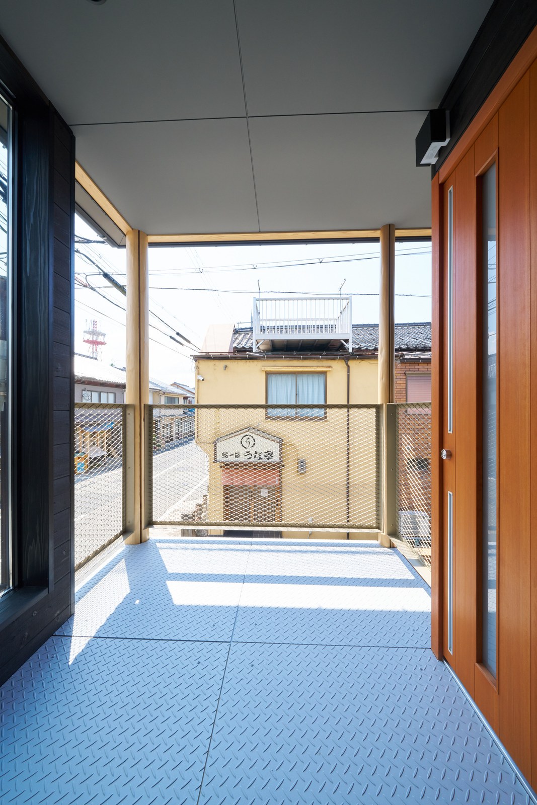 2階の入り口。木の扉と、街並みを望む踊り場